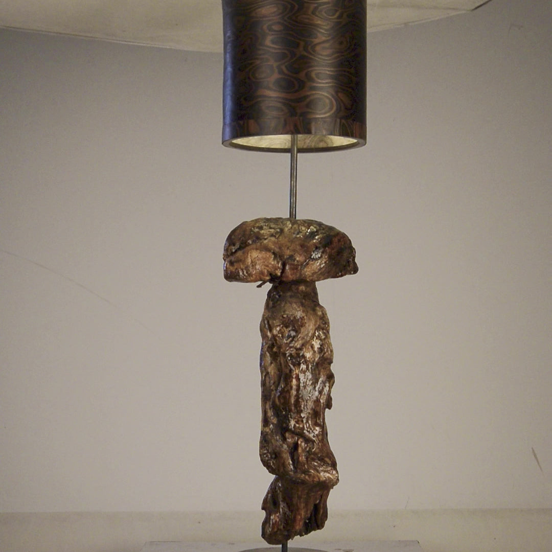 Driftwood Light Sculpture LO05 – Treibholz Lampe mit Echtholz Furnier & Beton-Sockel, beleuchtet im dunklen Raum mit Lichtreflexionen.